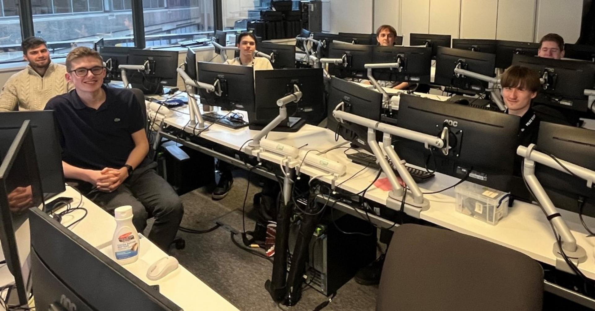 Six apprentices sat at desktop computers